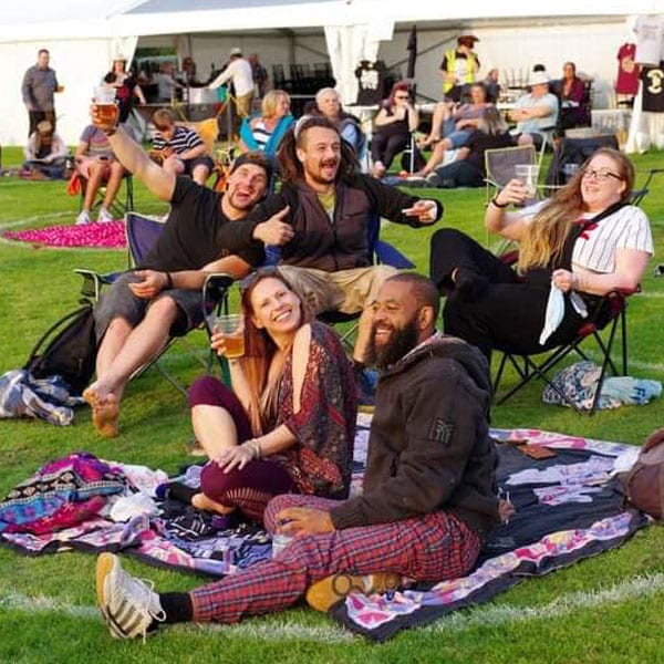 A crowd sat on the grass watching an event A crowd sat on the grass watching an event