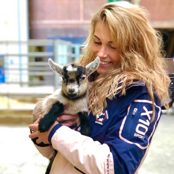 A pretty blond woman smiling and holding a Lamb