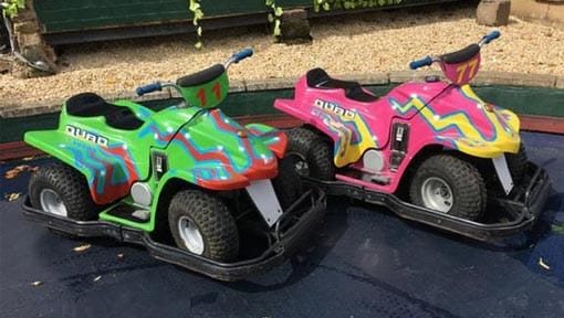 Brightly coloured electric quad bikes on the track Brightly coloured electric quad bikes on the track
