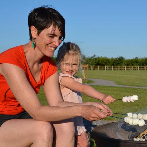 Mother and daughter having fun roasting marshmallows