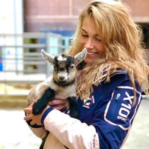 A pretty blond woman smiling and holding a Lamb